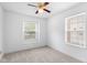 This empty bedroom features two windows, neutral carpet, and a ceiling fan at 5503 Wilder Way, Indianapolis, IN 46216