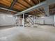 Large unfinished basement with white brick, open rafters and concrete floors provides ample space for storage or customization at 618 Miller Ave, Shelbyville, IN 46176