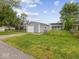 Property featuring a detached garage, green yard, and house in the background at 618 Miller Ave, Shelbyville, IN 46176