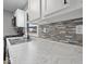 Stylish kitchen featuring marble countertops, stainless steel sink, and trendy backsplash at 618 Miller Ave, Shelbyville, IN 46176