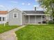View of the home's rear exterior with a covered porch and green lawn at 618 Miller Ave, Shelbyville, IN 46176