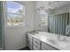 Bright bathroom with double sinks, a large mirror, and a window providing natural light at 654 N Senate Ave, Indianapolis, IN 46202