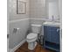 Charming powder room features unique wallpaper, blue vanity, and hardwood floors at 654 N Senate Ave, Indianapolis, IN 46202