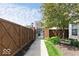Pathway leading to a wrought iron gate, framed by a wooden fence and lush greenery at 654 N Senate Ave, Indianapolis, IN 46202