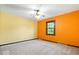 Spacious bedroom with orange and yellow walls, plush carpeting, and a ceiling fan at 659 Carson Ct, Carmel, IN 46033