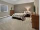 Bedroom with a patterned bedspread, wood dresser, small window, and plush carpet at 6693 W May Apple Dr, McCordsville, IN 46055