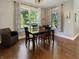Bright dining room with large windows, natural light, a wood table, and seating for a cozy meal at 6693 W May Apple Dr, McCordsville, IN 46055