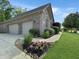 Brick home featuring a two-car garage, concrete driveway, and manicured landscaping at 6693 W May Apple Dr, McCordsville, IN 46055