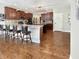 Expansive kitchen featuring rich wood cabinetry, granite countertops, island with seating, and hardwood floors at 6693 W May Apple Dr, McCordsville, IN 46055