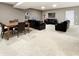 Open-concept living area featuring comfortable seating, a wooden dining table, and neutral carpet at 6693 W May Apple Dr, McCordsville, IN 46055