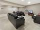 Spacious living room area featuring plush carpeting, stylish black leather sofas, and a dining area at 6693 W May Apple Dr, McCordsville, IN 46055