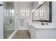 Elegant bathroom featuring double sinks, a large mirror, a glass shower, and tile flooring at 7077 Antiquity Dr, Carmel, IN 46033