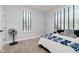 A bright bedroom with plush grey carpet and blue accent bedding, illuminated by natural light from two windows at 7077 Antiquity Dr, Carmel, IN 46033