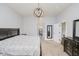 Serene primary bedroom with neutral tones, elegant lighting, and a view into the en-suite bathroom at 7077 Antiquity Dr, Carmel, IN 46033