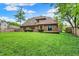 Brick home overlooking a large, green backyard with trees and a wood fence at 7513 Pine Royal Dr, Indianapolis, IN 46256