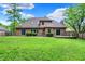 Brick home featuring a large backyard, sliding glass doors, and a small deck at 7513 Pine Royal Dr, Indianapolis, IN 46256