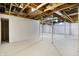 Open basement featuring painted white walls and floor, and an exposed unfinished ceiling at 7513 Pine Royal Dr, Indianapolis, IN 46256