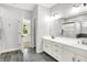 Bright bathroom featuring double vanity, tile floors, large mirror, and walk-in shower at 7513 Pine Royal Dr, Indianapolis, IN 46256