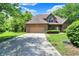 Well-maintained brick home with an attached garage, large driveway, and neatly landscaped front yard at 7513 Pine Royal Dr, Indianapolis, IN 46256