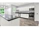 Renovated kitchen features white cabinets, stainless steel appliances, and sleek black countertops at 7513 Pine Royal Dr, Indianapolis, IN 46256