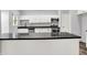 A kitchen boasts white cabinetry, stainless steel appliances, and a black countertop island at 7513 Pine Royal Dr, Indianapolis, IN 46256