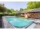 Inviting backyard area with a sparkling in-ground swimming pool, stone patio, and lush landscaping at 7575 Central Ave, Indianapolis, IN 46240