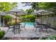 Relaxing backyard with in-ground pool, stone patio and tables with umbrellas for outdoor enjoyment at 7575 Central Ave, Indianapolis, IN 46240