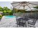 Outdoor living space featuring a refreshing pool, stone patio with tables and umbrellas, perfect for relaxation at 7575 Central Ave, Indianapolis, IN 46240