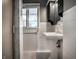 Classic bathroom with a pedestal sink, white tiled walls, and bright natural light from a large window at 7575 Central Ave, Indianapolis, IN 46240