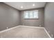 Simple bedroom with carpeted floors, neutral walls, and a window letting in natural light at 7575 Central Ave, Indianapolis, IN 46240