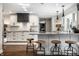 Well-lit kitchen featuring a large island with seating, white cabinets, and herringbone backsplash at 7575 Central Ave, Indianapolis, IN 46240