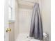 Bathroom featuring a tiled walk-in shower with a grey shower curtain and a window at 7734 Hoover Rd, Indianapolis, IN 46260