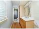 Bathroom featuring a vanity with a white countertop, wooden cabinets, and decorative wallpaper accents at 7734 Hoover Rd, Indianapolis, IN 46260