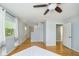 Bright bedroom featuring hardwood floors, a ceiling fan, and a staircase visible from the doorway at 7734 Hoover Rd, Indianapolis, IN 46260