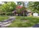 Lovely home with a paved driveway, lush green lawn, and beautiful mature trees in a serene setting at 7734 Hoover Rd, Indianapolis, IN 46260