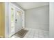 Bright foyer with white tile flooring, a classic white door, and elegant wall trim detail at 7734 Hoover Rd, Indianapolis, IN 46260