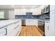 Beautifully updated kitchen featuring white cabinets, a center island, stainless steel appliances, and wood flooring at 7734 Hoover Rd, Indianapolis, IN 46260