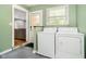 Functional laundry room with washer, dryer, and convenient access to the backyard at 7734 Hoover Rd, Indianapolis, IN 46260