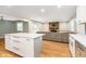 Open concept kitchen flowing into a living room with a brick fireplace and hardwood flooring at 7734 Hoover Rd, Indianapolis, IN 46260