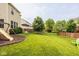 A lovely backyard with a wooden fence, featuring a swing set, a deck, and ample green space at 7824 Hedgehop Dr, Zionsville, IN 46077
