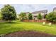 Spacious backyard features a well-maintained lawn, trees, and a cozy seating area with green Adirondack chairs at 7824 Hedgehop Dr, Zionsville, IN 46077