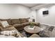 Basement with a sectional couch, warm lighting, modern design elements, and a neutral color palette at 7824 Hedgehop Dr, Zionsville, IN 46077