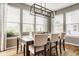 Bright dining room featuring wood floors, neutral colors, modern lighting, and multiple windows at 7824 Hedgehop Dr, Zionsville, IN 46077