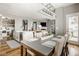 Open-concept dining and living room with modern lighting fixture and eat-in kitchen island at 7824 Hedgehop Dr, Zionsville, IN 46077