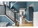Elegant foyer boasting hardwood floors, a staircase, stylish wallpaper, and blue walls at 7824 Hedgehop Dr, Zionsville, IN 46077