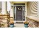 Inviting front entrance with a dark-colored door, decorative wreath, sidelights, and potted plants at 7824 Hedgehop Dr, Zionsville, IN 46077