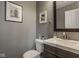 Chic powder room features a dark vanity, white countertop, and modern artwork at 7824 Hedgehop Dr, Zionsville, IN 46077