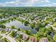 Stunning aerial view of homes in a suburban neighborhood surrounding a serene lake with lush green trees at 7970 Cobblesprings Dr, Avon, IN 46123