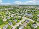 Gorgeous aerial view of homes in a suburban neighborhood surrounding a pond with lush green trees at 7970 Cobblesprings Dr, Avon, IN 46123