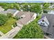 Aerial view of a well-maintained home, featuring an attached garage, lush greenery, and a serene lake nearby at 7970 Cobblesprings Dr, Avon, IN 46123
